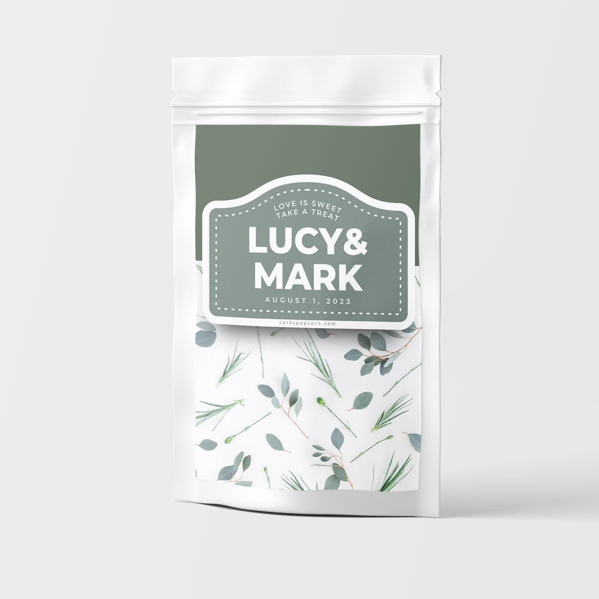 Custom wedding popcorn bag with a sage green "Lucy & Mark" label and eucalyptus pattern
