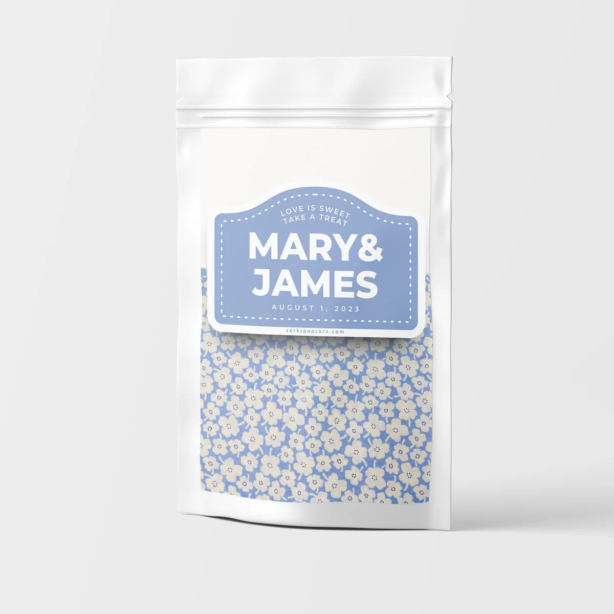 Custom wedding popcorn bag with a blue "Mary & James" label and daisy pattern