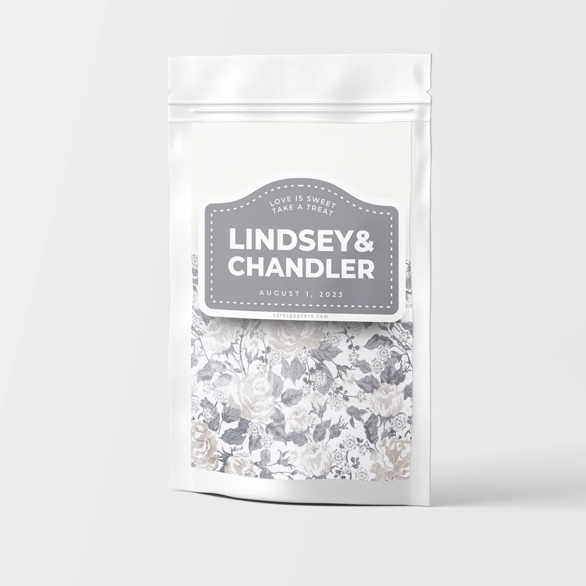 Custom wedding popcorn bag with a gray "Lindsey & Chandler" label and black-and-white floral pattern